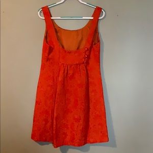 Orange quilted dress with back detail buttons.